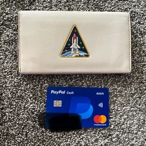 Gently used Coach x NASA Glovetanned Leather Phone Wallet “Shuttle Take Off.”